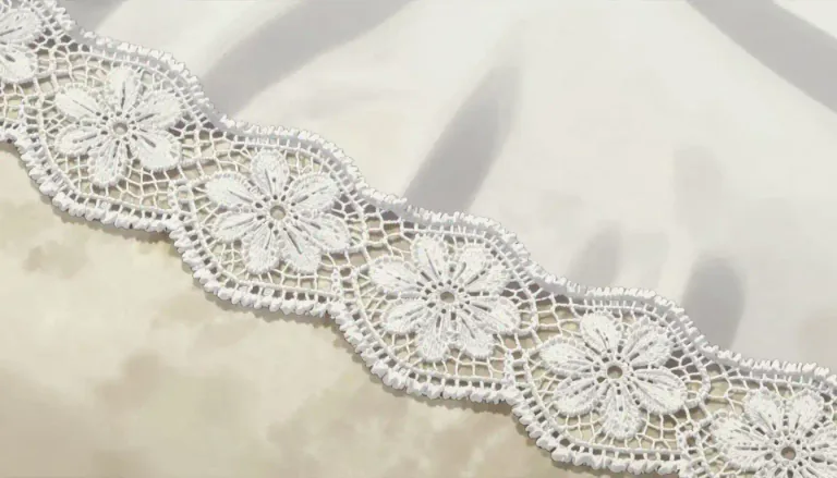 Visual representation of "lace" - A thin strip of fabric with a design that is usually woven into it